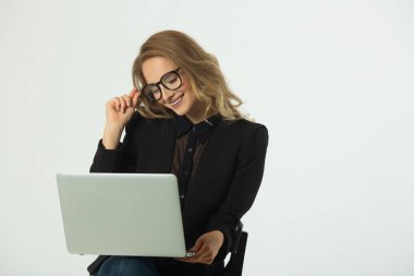 güzel genç kız ile bir laptop beyaz bir arka plan üzerinde siyah bir takım elbise içinde gözlüklü