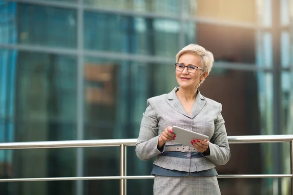 beautiful stylish woman with a short haircut in a suit with a tablet in her hands