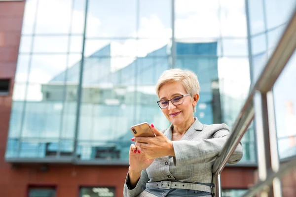 beautiful stylish woman with a short haircut in a suit with a phone in her hand