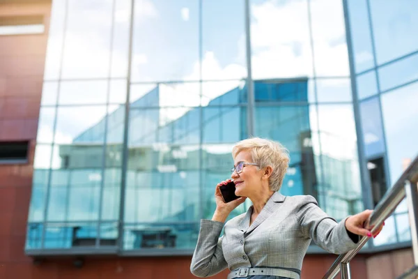 beautiful stylish woman with a short haircut in a suit calls on the phone