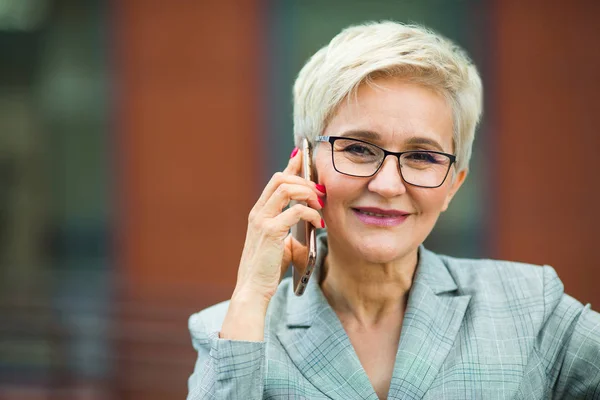 beautiful stylish woman with a short haircut in a suit calls on the phone