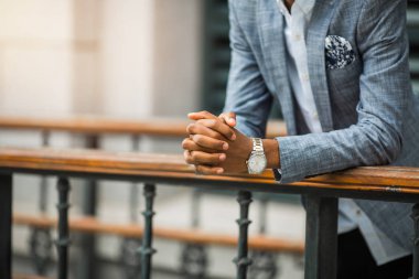 Saati olan takım elbiseli bir adamın elleri.