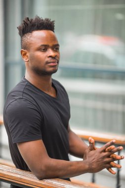Siyah tişörtlü yakışıklı Afrikalı genç adam.