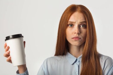 Güzel, genç bir kadın. Kızıl saçlı. Beyaz bir arka planda elinde içki var.