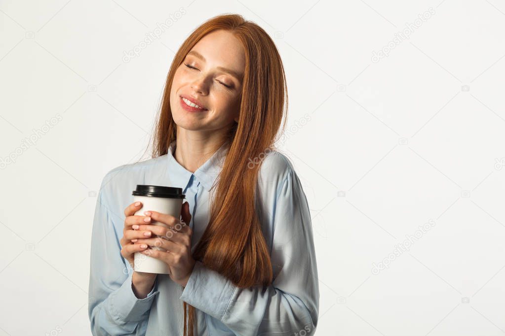 beautiful young woman with red hair with a drink in hand on a white background