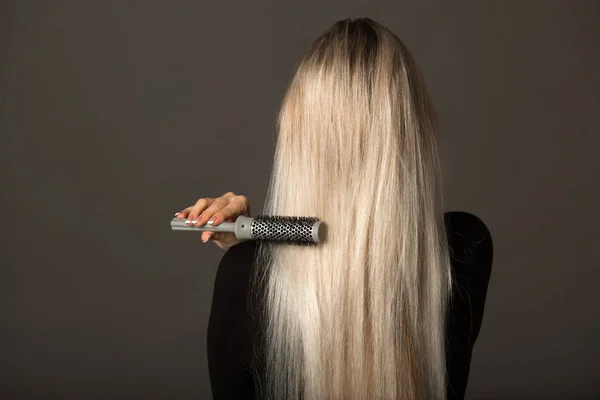 Bela Jovem Mulher Com Cabelos Longos Fundo Preto Penteia Seu — Fotografia de Stock