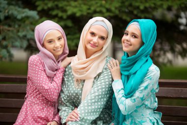 Yazın parkta Müslüman elbiseli üç güzel genç kadın.