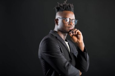 Siyah arka planda gözlüklü yakışıklı Afrikalı bir adam.