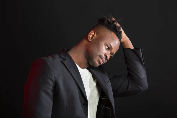 handsome african man in suit on black background