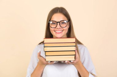Ellerinde kitaplarla gözlüklü güzel bir genç kadın.