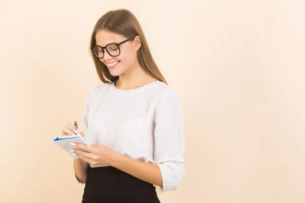 Hermosa Mujer Joven Gafas Sobre Fondo Beige Con Bloc Notas — Foto de Stock