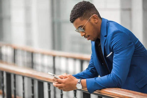 Stilig Ung Afrikan Man Blå Jacka Med Telefon Handen Glasögon — Stockfoto