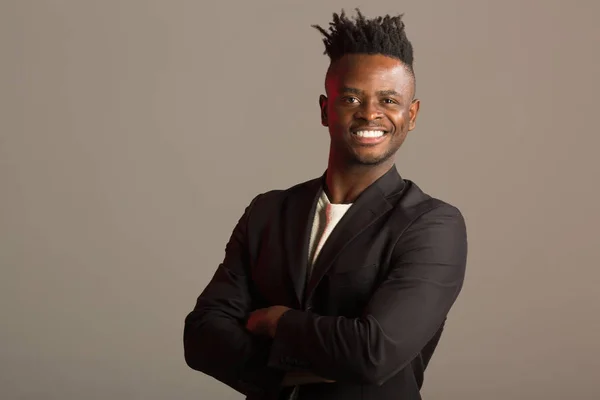 handsome african man in black suit on gray background