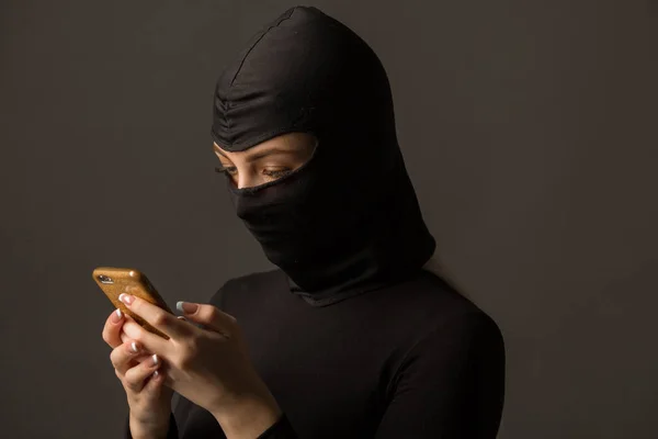 Onbekende Vrouw Een Zwart Masker Met Een Telefoon Haar Handen — Stockfoto