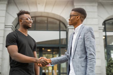 İki yakışıklı Afrikalı adam el sıkışıyor.