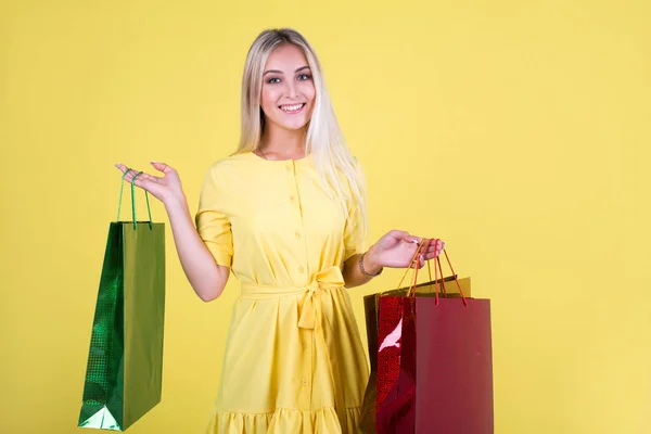 Bela Jovem Mulher Vestido Fundo Amarelo Com Pacotes Mãos — Fotografia de Stock