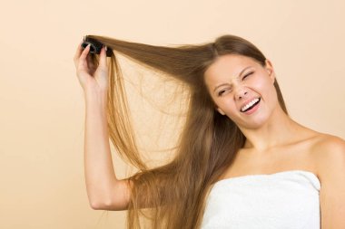 Bej arka planda, saçları karışık güzel bir kadın.