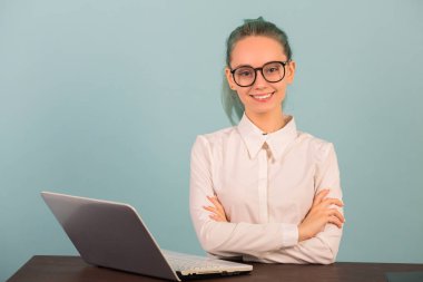 Güzel genç bir kadın dizüstü bilgisayarla masada uyuyor.