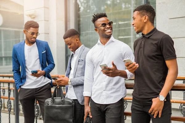 Fyra Unga Afrikanska Män Nära Byggnaden Sommaren Med Telefoner Händerna — Stockfoto