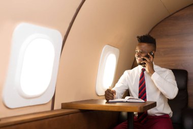 Beyaz gömlekli yakışıklı afrikalı adam uçak koltuğunda