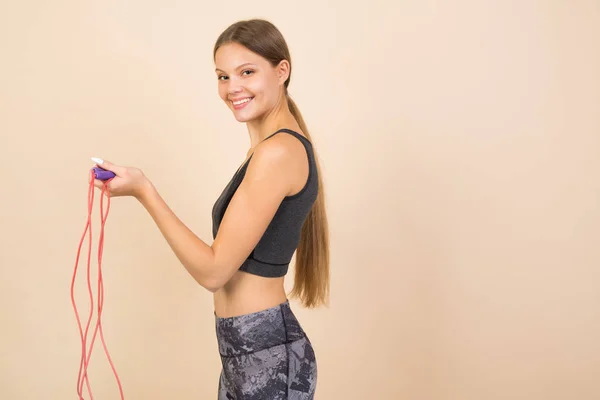 Hermosa Joven Ropa Deportiva Sobre Fondo Beige Con Una Cuerda — Foto de Stock