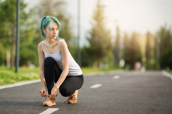 beautiful young woman with a slim figure is jogging in the summer in the park