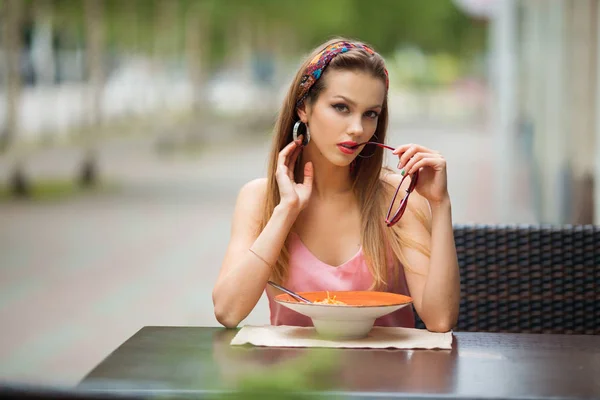 美しい若い女性が通りのレストランで夏のスパゲティを食べる — ストック写真