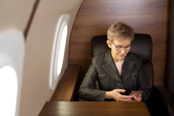 Hermosa Mujer Elegante Envejecida Cabina Avión Privado Con Teléfono Mano — Foto de Stock