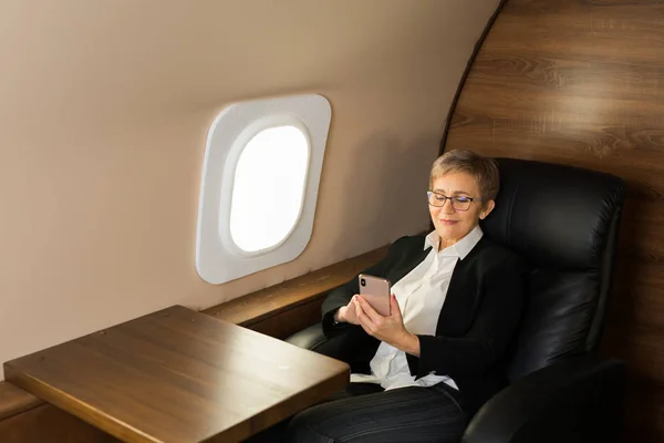 Hermosa Anciana Cabina Avión Privado Sillón Con Teléfono Sus Manos — Foto de Stock