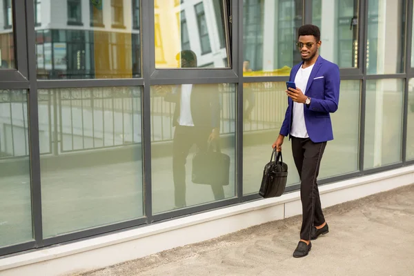 Stilig Ung Afrikan Man Kostym Med Telefon Händerna Nära Glasbyggnad — Stockfoto