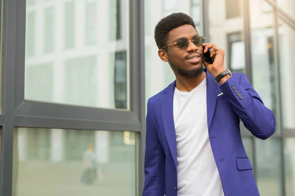 Stilig Ung Afrikan Man Kostym Med Telefon Händerna Nära Glasbyggnad — Stockfoto