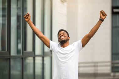 Elleri havada genç bir Afrikalı.