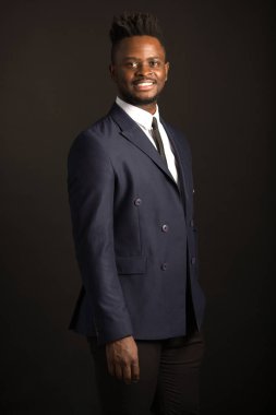 Siyah arka planda takım elbiseli yakışıklı bir Afrikalı.