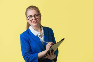 Sarı arka planda mavi ceketli güzel bir kadın.