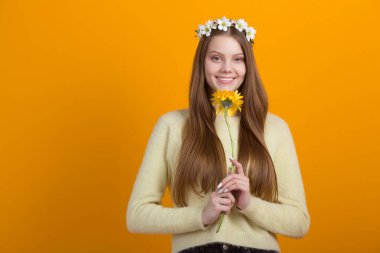 Sarı arka planda başında çelenk olan güzel genç bir kadın.