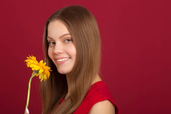 Hermosa Joven Con Una Flor Sus Manos Sobre Fondo Rojo —  Fotos de Stock