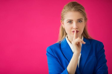 Pembe arka planda mavi ceketli güzel bir kadın.