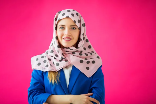 beautiful young woman in a scarf on a pink background