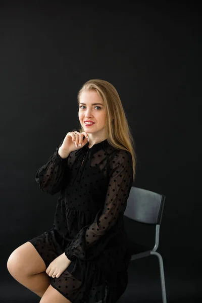 黒の背景に黒のドレスで美しい若い女性 — ストック写真