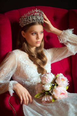 Siyah arka planda beyaz elbiseli güzel bir kadının portresi.