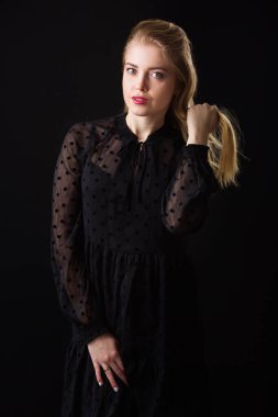 Makyajlı ve siyah arka planda saçları olan güzel bir kadın.