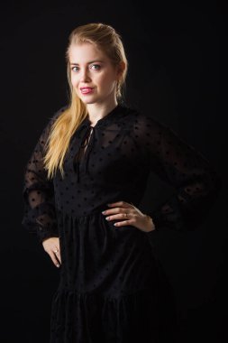 Makyajlı ve siyah arka planda saçları olan güzel bir kadın.