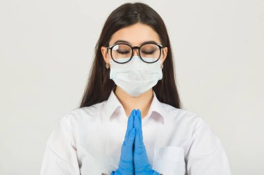 El hareketleriyle beyaz arka planda tıbbi maskeli genç bir kadın.