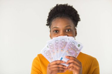 Beyaz arka planda, elinde avroyla güzel, genç bir Afrikalı kadın.