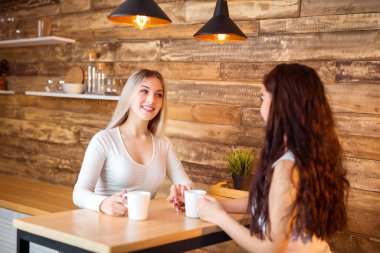 Masada iki güzel genç bayan oturuyor.