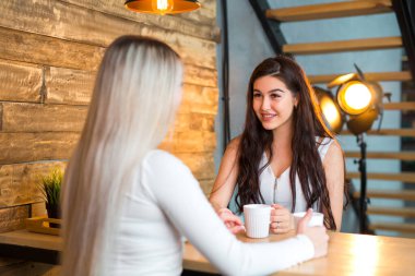 Masada iki güzel genç bayan oturuyor.