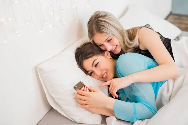 Zwei Schöne Junge Frauen Schlafzimmer Auf Dem Bett Mit Telefon — Stockfoto