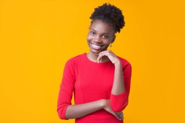 Sarı arka planda kırmızı elbiseli güzel bir Afrikalı kadın.