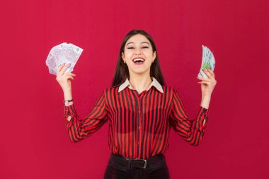 Avrosu avucunun içinde, kırmızı bir arka planı olan güzel genç bir kadın.