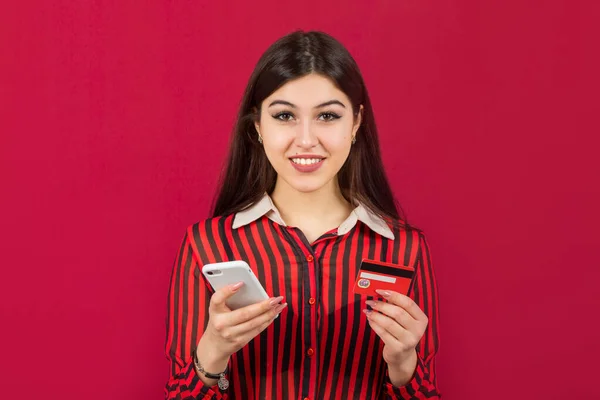 Красива Молода Жінка Кредитною Карткою Телефоном Червоному Тлі — стокове фото